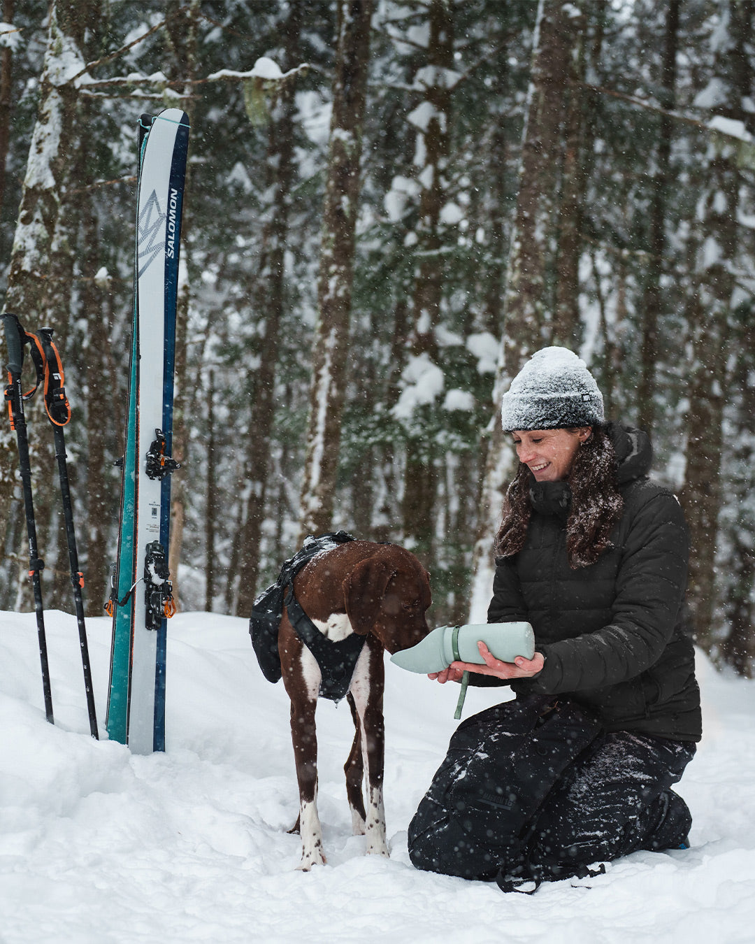 Woman giving water to her dog in the Slurpy Sack 2.0