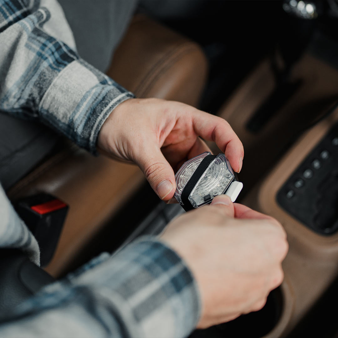 Picture of a man charging his pitchblack night light 2.0 in the car with the USB cable